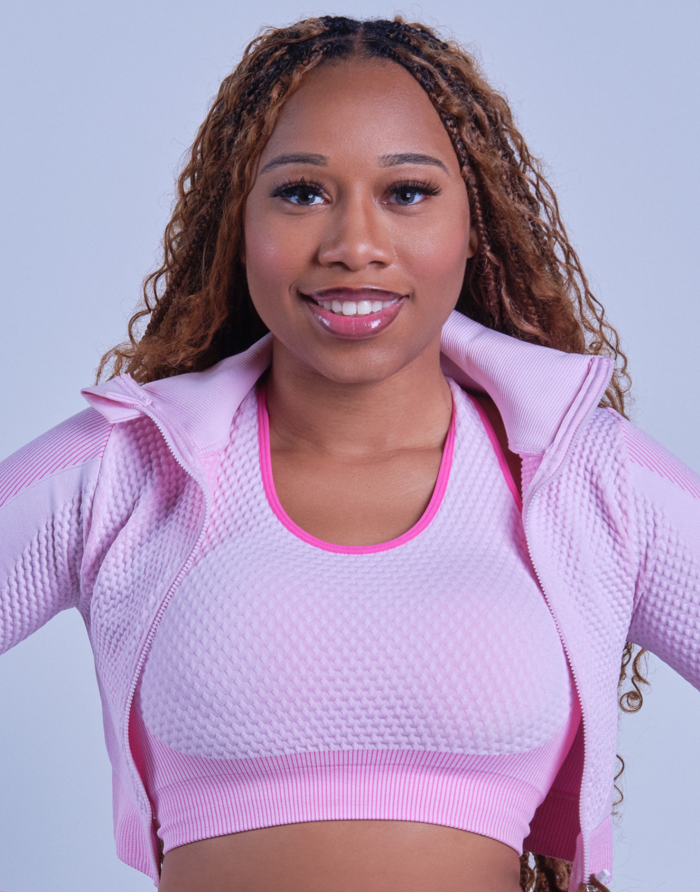 Close-up smiling commercial portrait of Taniya in a pink activewear set