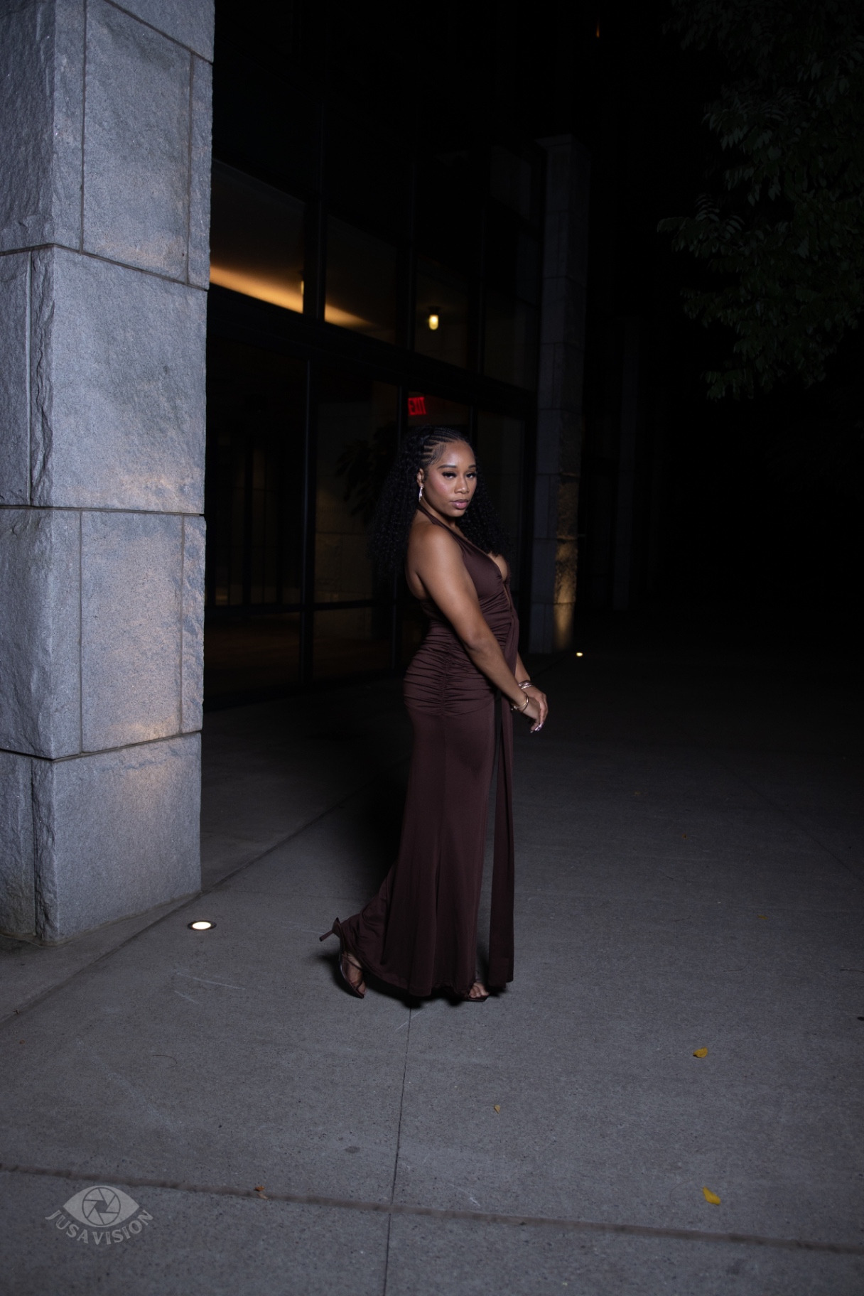 Side profile of Taniya in a chocolate brown floor-length gown at night