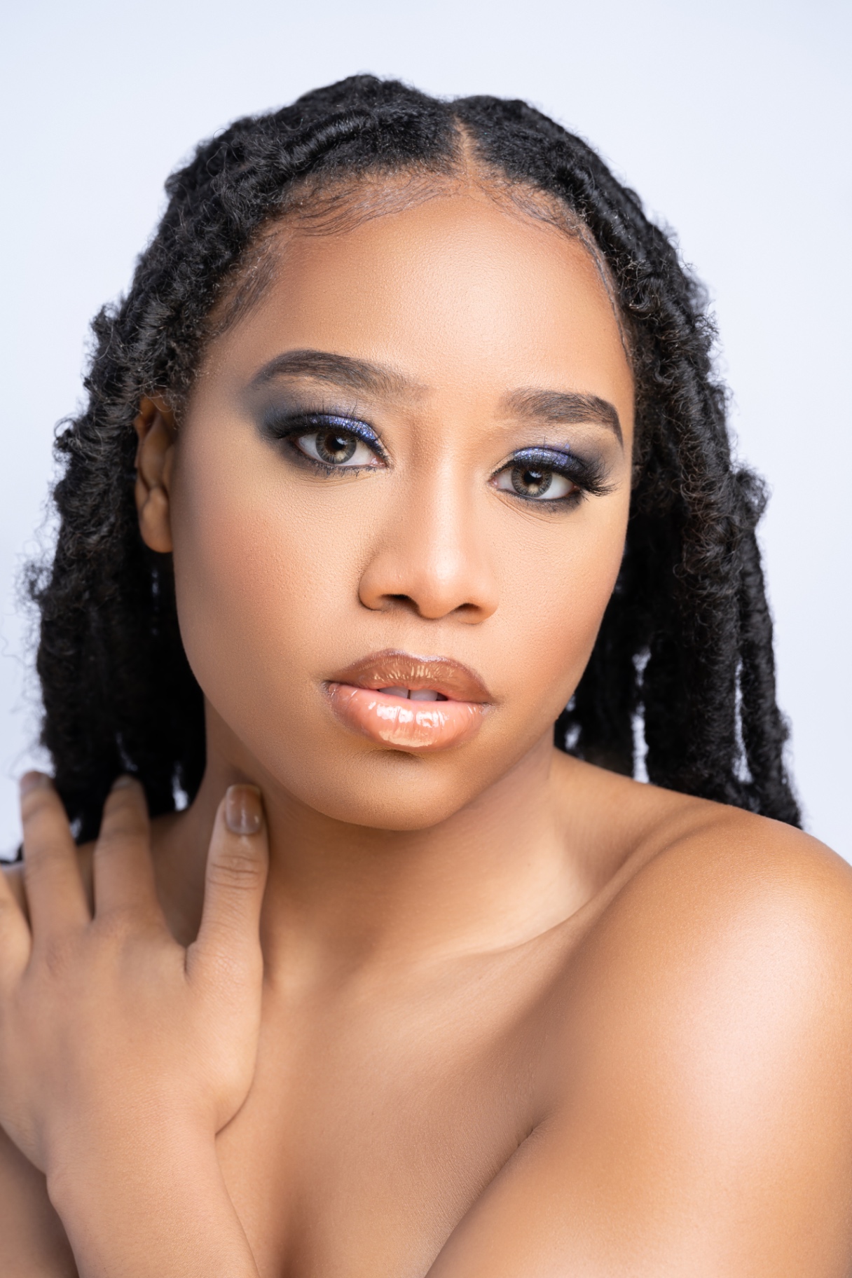 Beauty close-up of Taniya with locs, smoky blue eye makeup and glossed lips