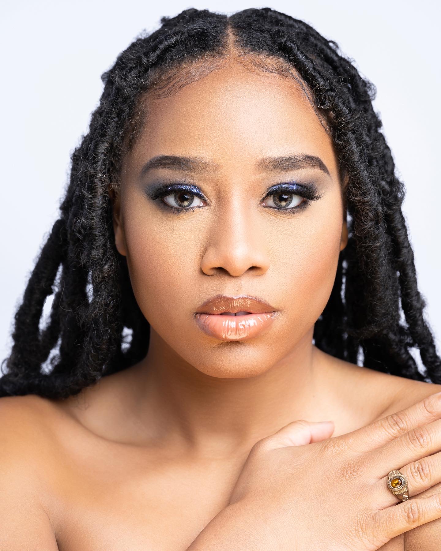 Beauty close-up of Taniya with locs and blue metallic eye makeup